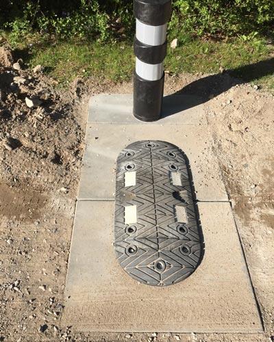 TDJ Typegodkendt Vejbump 20 km/t med kunststofpullert fra trafikgummi.dk. Monteret på grusvej på fliser. Bump med pullert / steler fra trafikgummi.dk TDJ Typegodkendt Vejbump 20 km/t med kunststofpullert fra trafikgummi.dk. Monteret på grusvej på fliser. Bump med pullert / steler fra trafikgummi.dk