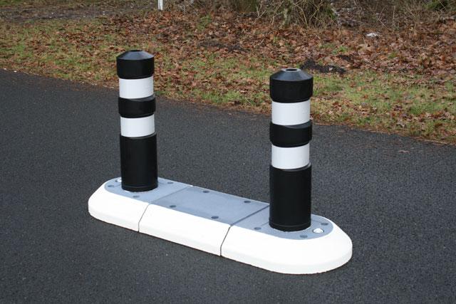 TDJ Helleblok med pullert / Steler fra trafikgummi.dk. Indsnævring, vejindsnævring, helleanlæg, vejchikane, chikane. Kunststofpullert