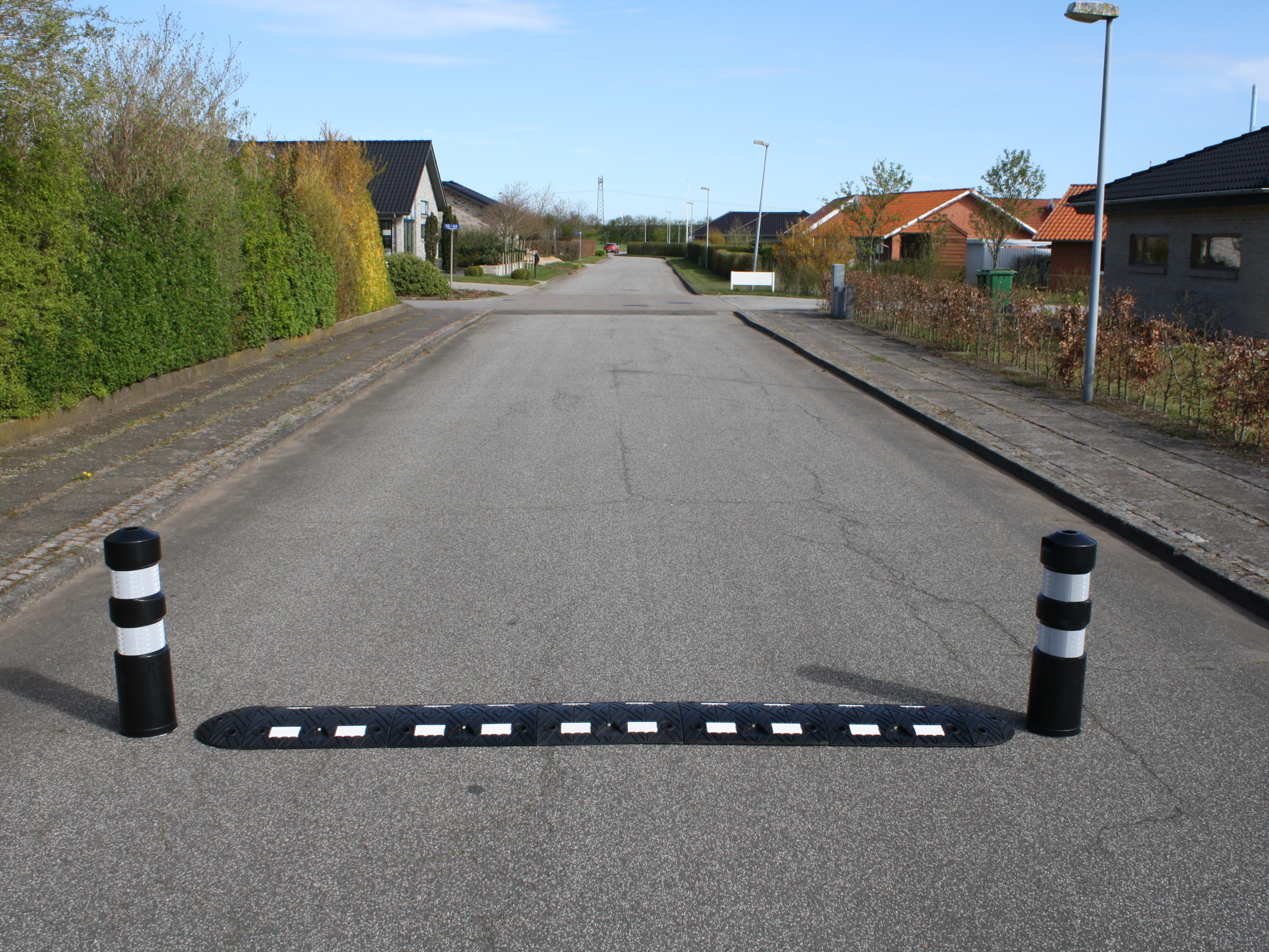 Fartzone 20km/t TDJ Vejbump 30 km/t med pullert. Bump på grusvej ved sommerhusområde. Typegodkendt af vejdirektoratet. Trafikgummi.dk